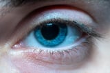 Everyone with ordinary inherited blue eyes appears to share a common ancestor, probably someone who lived around 6,000 to 10,000 years ago, when a tiny genetic switch near the OCA2 gene reduced brown pigment in the iris — meaning blue eyes, as we know them today, may trace back to one ancient mutation.