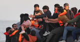 Unbelievable moment dozens of migrants charge into Channel in desperate bid to reach UK