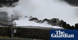 NSW wild weather: dam spill heightens flood threat as storm wreaks havoc